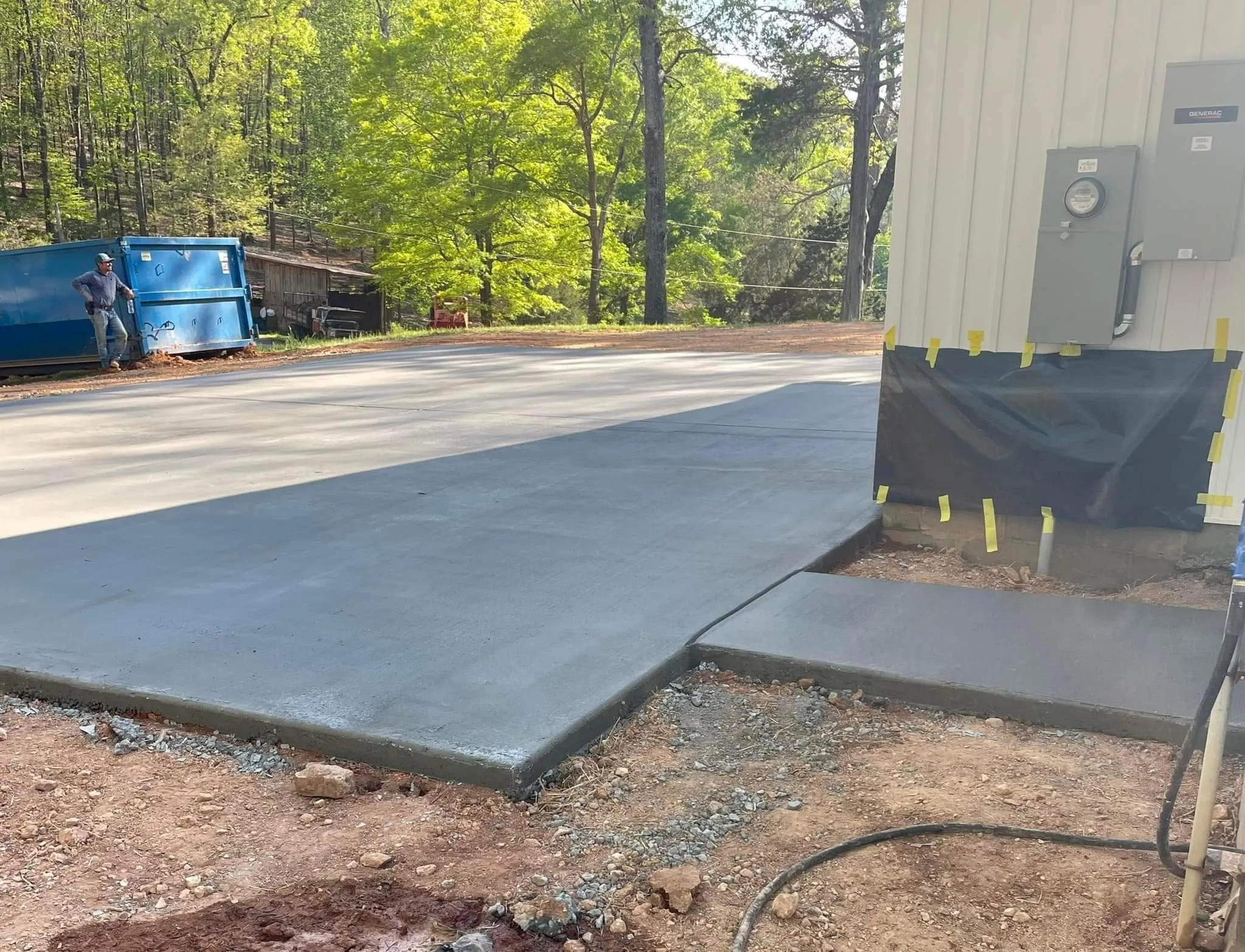 Fresh concrete pour for a shop pad and apron being finished